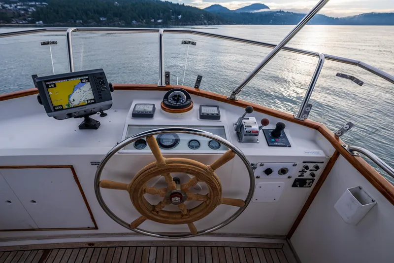 Skagit Song Yacht Photos Pics 1984 Grand Banks 36 Sedan helm with wooden wheel and navigation equipment on calm waters.