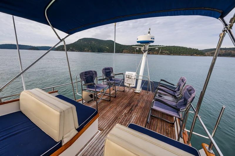 Skagit Song Yacht Photos Pics 1984 Grand Banks 36 Sedan deck with seating, overlooking serene waters and distant hills.