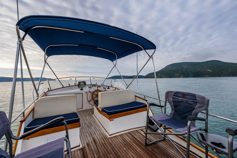 Skagit Song Yacht Photos Pics 1984 Grand Banks 36 Sedan boat deck with seating, blue canopy, and scenic water view.