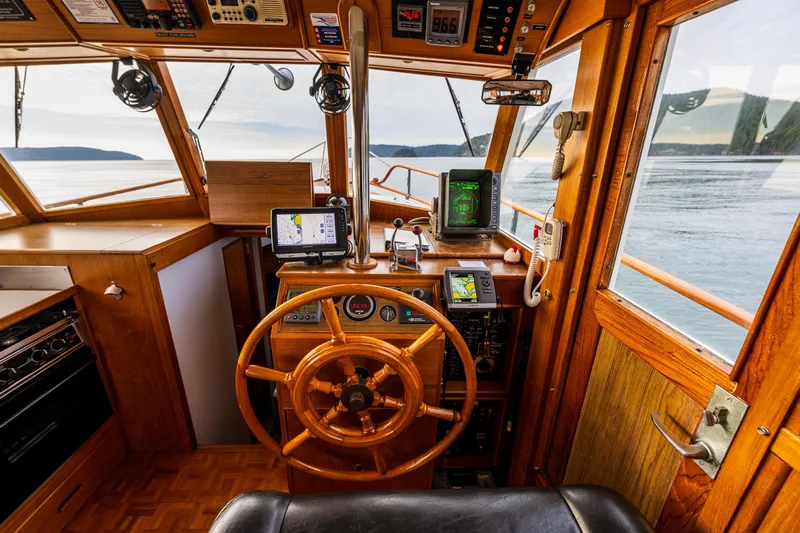 Skagit Song Yacht Photos Pics 1984 Grand Banks 36 Sedan helm with wooden wheel and navigation equipment.