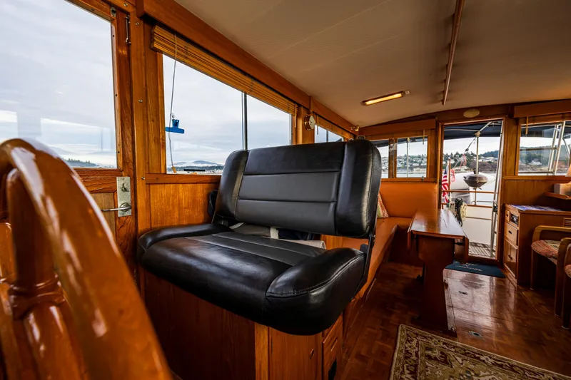 Skagit Song Yacht Photos Pics Interior of 1984 Grand Banks 36 Sedan, featuring a black captain's chair and wooden accents.