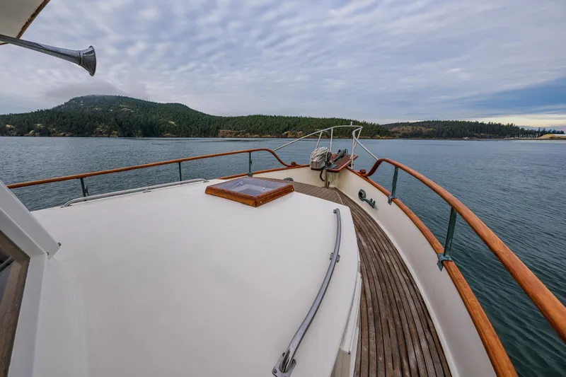 Skagit Song Yacht Photos Pics 1984 Grand Banks 36 Sedan yacht on calm water with scenic forested shoreline.