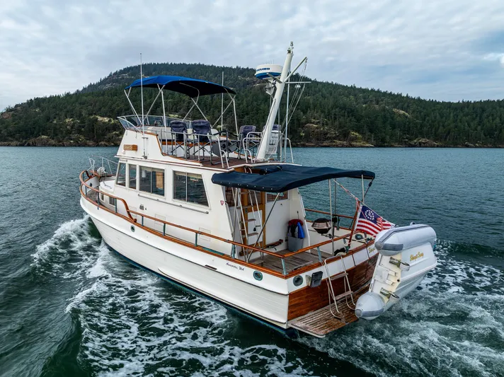 Skagit Song Yacht Photos Pics 1984 Grand Banks 36 Sedan cruising on a scenic lake with forested hills in the background.