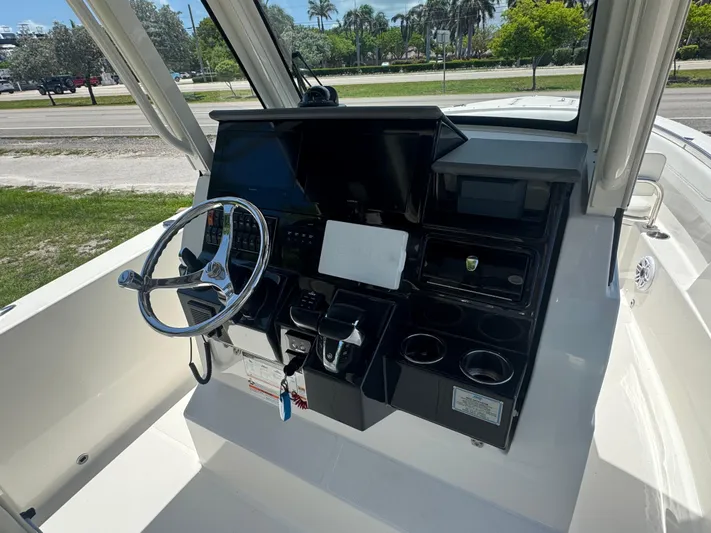  Yacht Photos Pics 2022 Pursuit S 288 Sport boat dashboard with steering wheel and control panel.