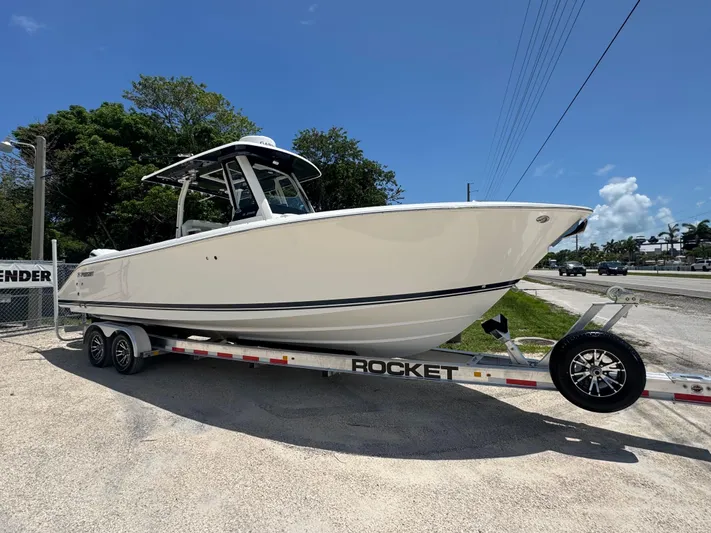  Yacht Photos Pics 2022 Pursuit S 288 Sport boat on trailer, parked outdoors under clear sky.