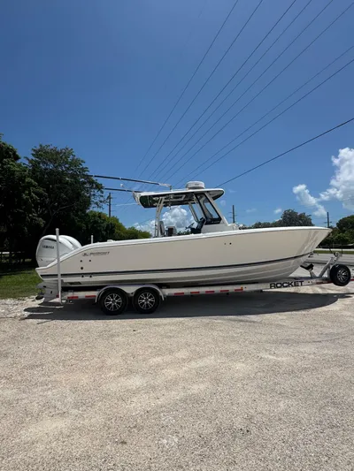  Yacht Photos Pics 2022 Pursuit S 288 Sport boat on trailer under clear blue sky.