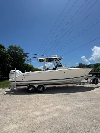  Yacht Photos Pics 2022 Pursuit S 288 Sport boat on trailer under clear blue sky.