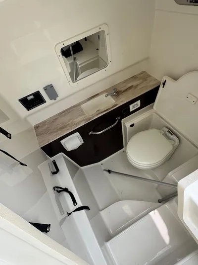  Yacht Photos Pics 2022 Pursuit S 288 Sport boat interior with compact bathroom and modern amenities.