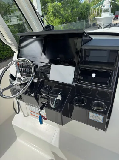  Yacht Photos Pics 2022 Pursuit S 288 Sport boat dashboard with steering wheel and control panels.