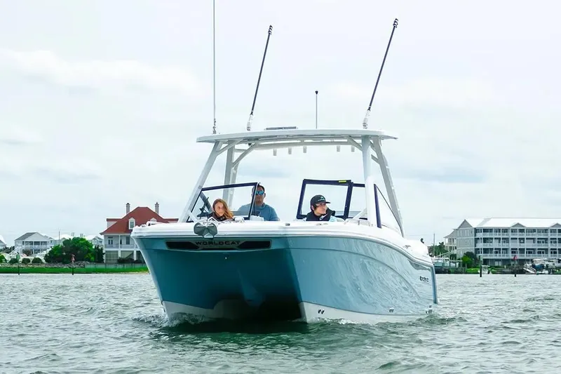 Yacht Photos Pics Manufacturer Provided Image: 2026 World Cat 265 DC-X boat cruising on a calm waterway near coastal homes.