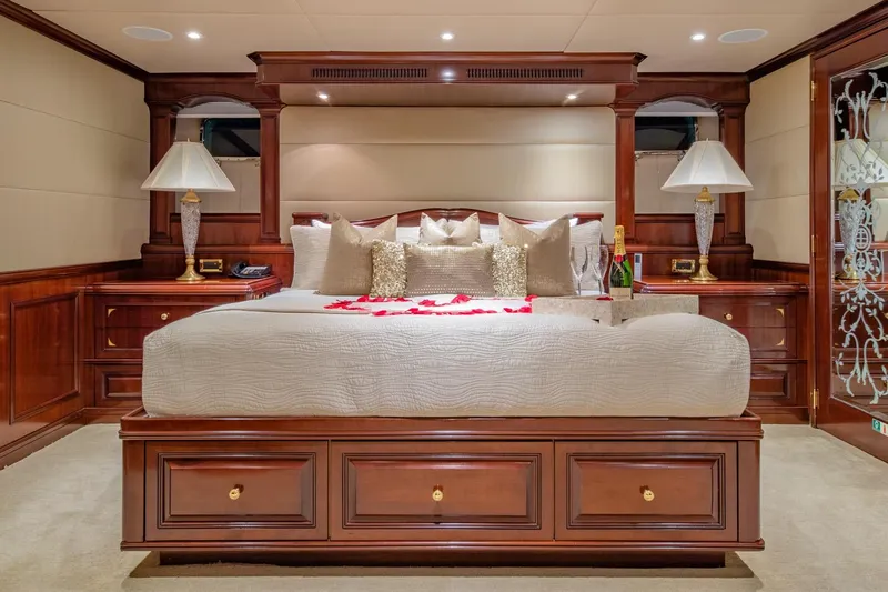 Starship Yacht Photos Pics Luxurious bedroom interior on 1986 Van Mill 144 Motor Yacht, featuring elegant wood furnishings.