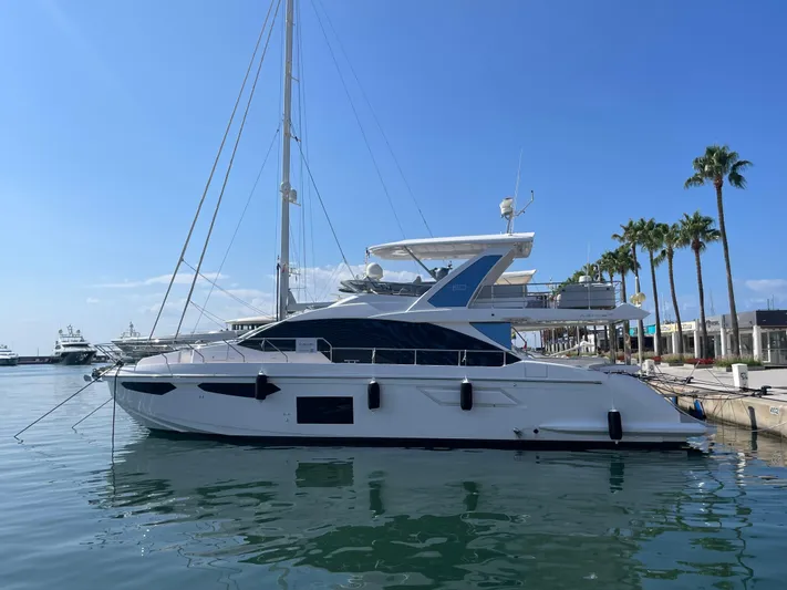 Melita Yacht Photos Pics Azimut 60 Flybridge 2023 yacht docked at marina, clear blue sky, palm trees in background.