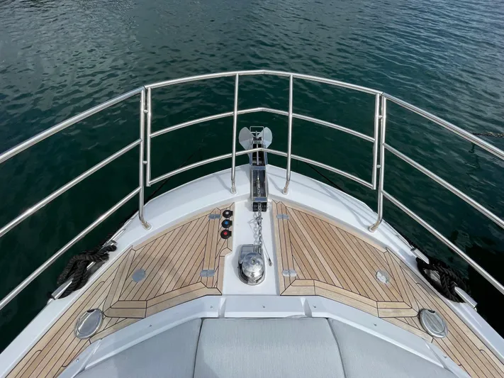 Melita Yacht Photos Pics Bow view of 2023 Azimut 60 Flybridge yacht with teak decking and stainless steel railings.