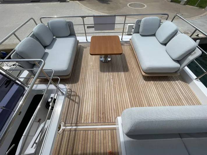 Melita Yacht Photos Pics Azimut 60 Flybridge 2023 yacht deck with cushioned seating and wooden table.