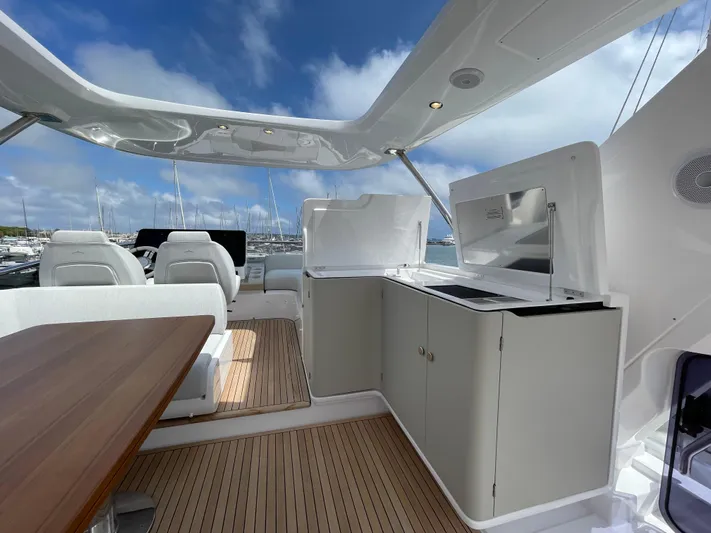 Melita Yacht Photos Pics Azimut 60 Flybridge 2023 yacht interior with seating and cabinetry under blue sky.