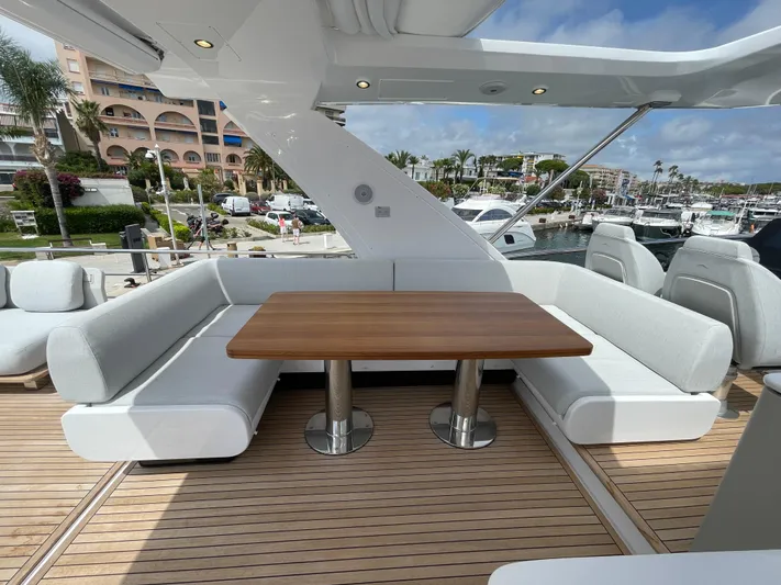 Melita Yacht Photos Pics Luxurious Azimut 60 Flybridge 2023 yacht deck with elegant seating and wooden table.