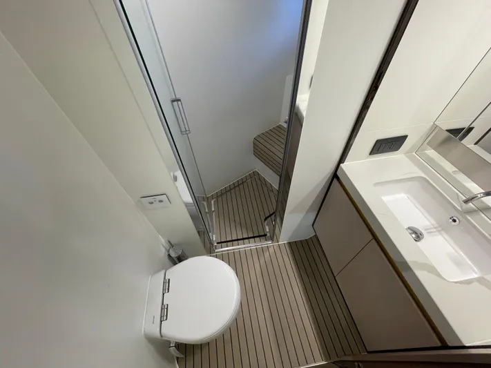 Melita Yacht Photos Pics Luxurious bathroom in 2023 Azimut 60 Flybridge yacht with modern fixtures and wood flooring.