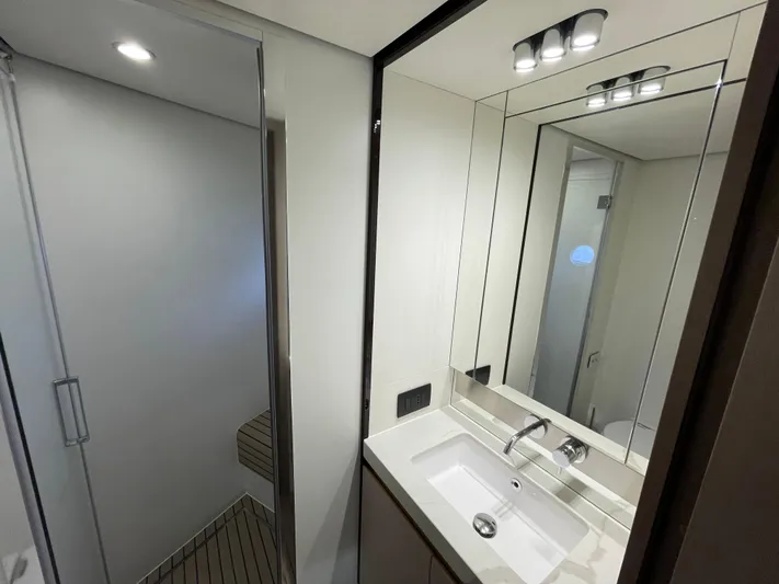 Melita Yacht Photos Pics Modern bathroom interior on Azimut 60 Flybridge 2023 yacht, featuring sleek sink and mirror.