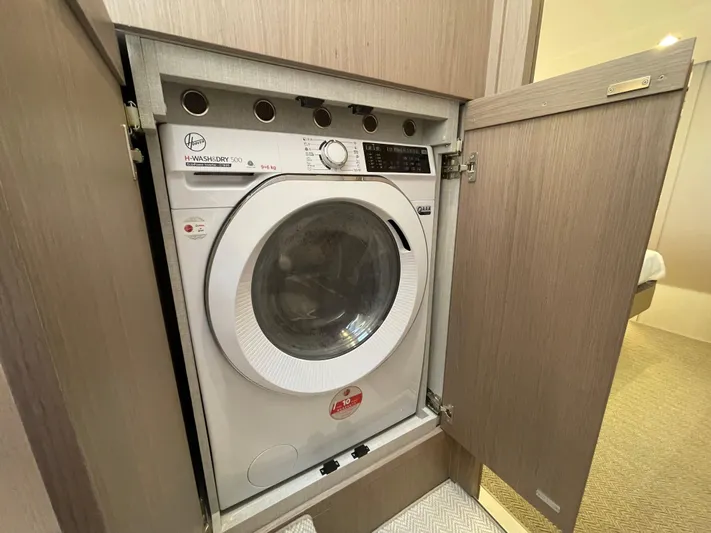 Melita Yacht Photos Pics Built-in washing machine on Azimut 60 Flybridge 2023 yacht, behind wooden cabinet door.