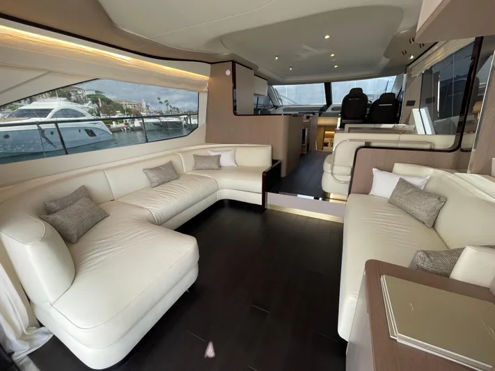Melita Yacht Photos Pics Luxurious interior of 2023 Azimut 60 Flybridge yacht with elegant white seating and large windows.