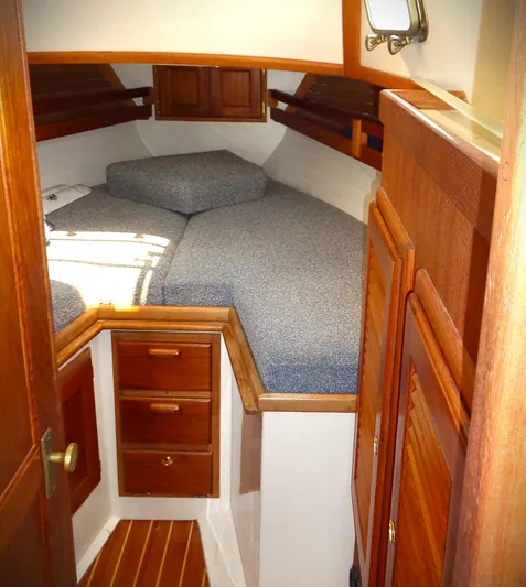 Scout Yacht Photos Pics Cozy cabin interior of 1998 Pacific Seacraft 34 sailboat with wooden cabinetry and cushioned berth.