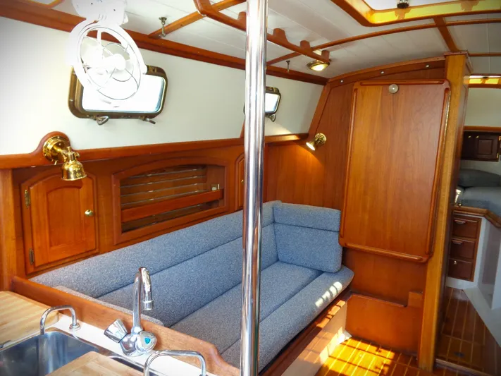 Scout Yacht Photos Pics Interior of 1998 Pacific Seacraft 34 sailboat with wooden finish and blue seating.