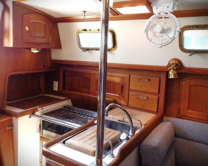 Scout Yacht Photos Pics Interior of 1998 Pacific Seacraft 34 sailboat, featuring a wooden galley with stove and sink.