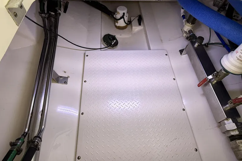 Ghost Yacht Photos Pics Engine compartment of a 2012 Everglades 350LX boat, featuring pipes and mechanical components.