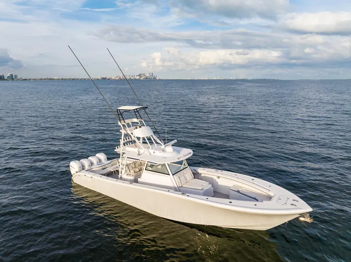  Yacht Photos Pics 2022 Yellowfin 42 boat on open water with city skyline in background.