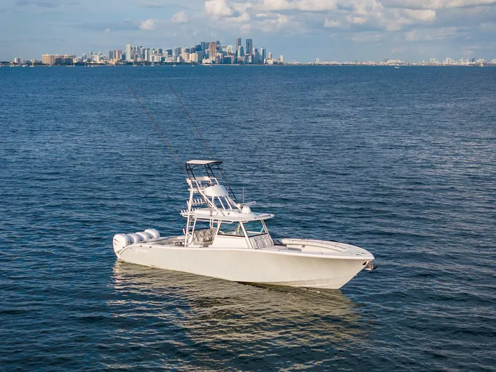  Yacht Photos Pics 2022 Yellowfin 42 boat on open water with city skyline in the background.