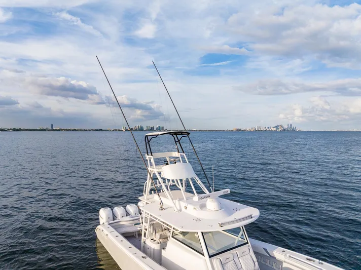  Yacht Photos Pics 2022 Yellowfin 42 boat on calm waters with city skyline in the background.