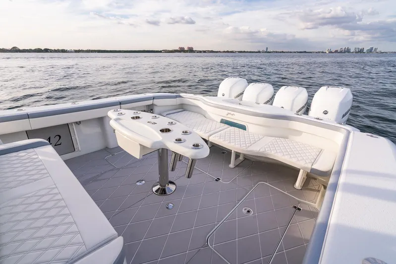  Yacht Photos Pics 2022 Yellowfin 42 boat with spacious seating and multiple outboard engines on the water.