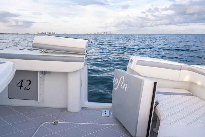  Yacht Photos Pics 2022 Yellowfin 42 boat on open water with city skyline in the distance.