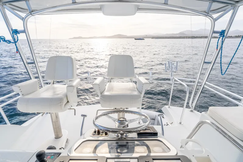 Determined Yacht Photos Pics Helm of 2003 Hatteras 60 Convertible yacht overlooking the ocean at sunset.