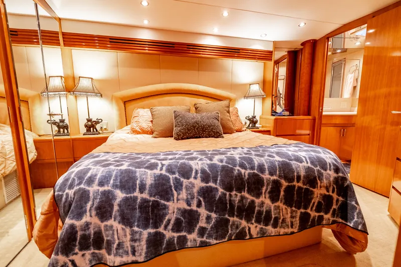 Determined Yacht Photos Pics Luxurious bedroom interior of 2003 Hatteras 60 Convertible yacht with elegant bedding and warm lighting.