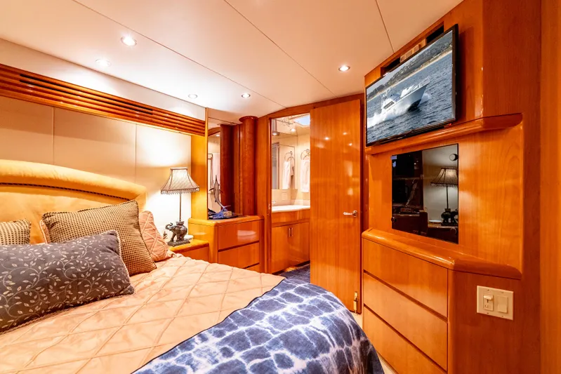 Determined Yacht Photos Pics Luxurious bedroom interior of 2003 Hatteras 60 Convertible yacht with wood finishes and TV.