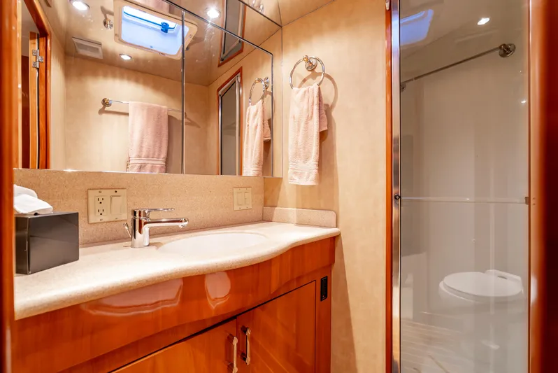 Determined Yacht Photos Pics Luxurious bathroom in a 2003 Hatteras 60 Convertible yacht, featuring elegant wood cabinetry and modern fixtures.