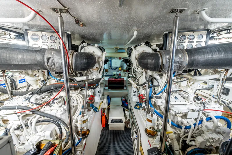 Determined Yacht Photos Pics Engine room of 2003 Hatteras 60 Convertible yacht, showcasing dual engines and complex machinery.