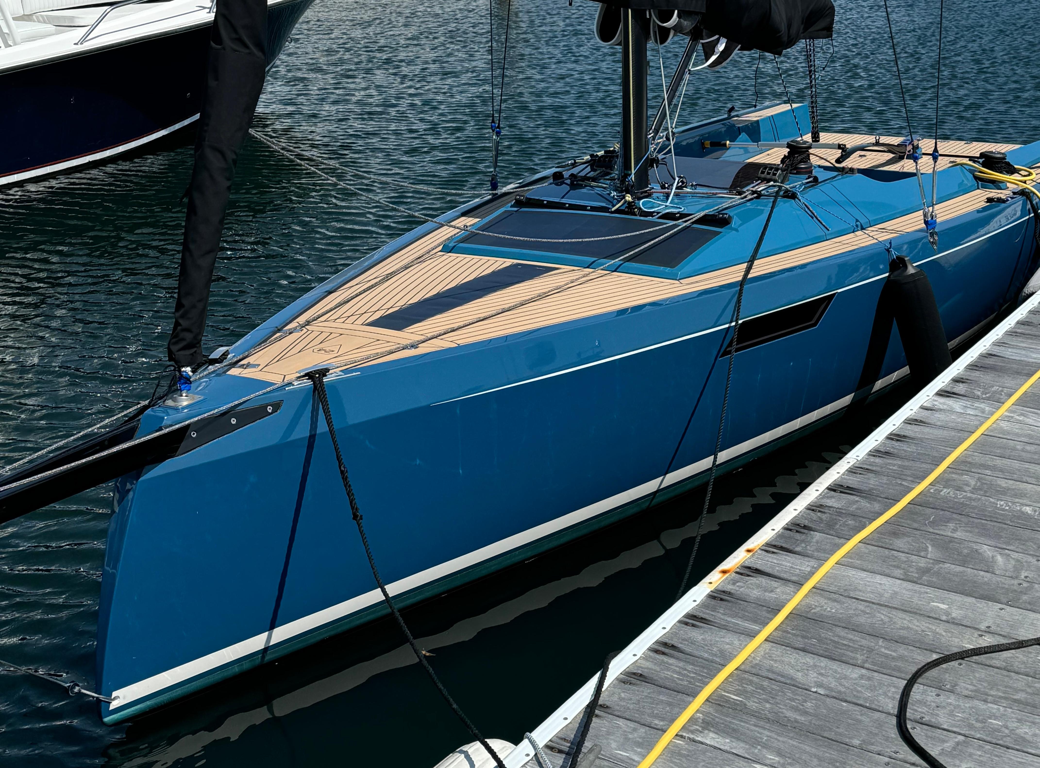 2023 Saffier 24 Lite sailboat docked, featuring sleek blue design and wooden deck.