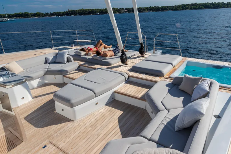 Serenissima III Yacht Photos Pics Luxurious deck of 2025 Fountaine Pajot Thira 80 yacht with sun loungers and jacuzzi.