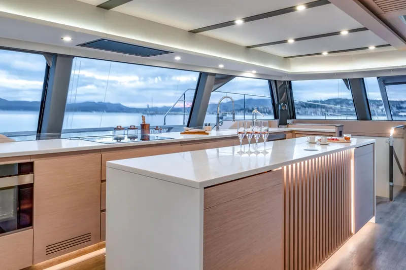 Serenissima III Yacht Photos Pics Luxurious interior of 2025 Fountaine Pajot Thira 80 yacht with modern kitchen design.