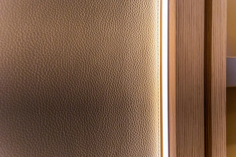 Serenissima III Yacht Photos Pics Close-up of Fountaine Pajot Thira 80 interior, featuring textured leather and wood paneling, 2025 model.