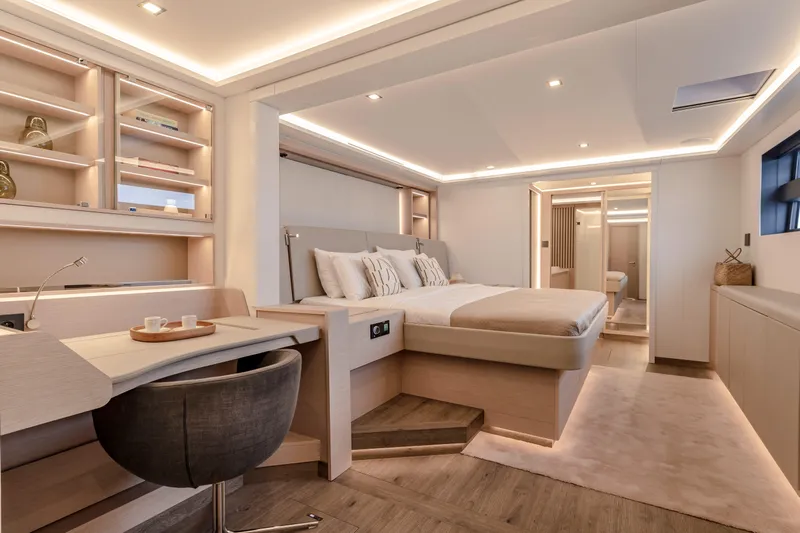 Serenissima III Yacht Photos Pics Luxurious interior of 2025 Fountaine Pajot Thira 80 yacht, featuring elegant bedroom and workspace.