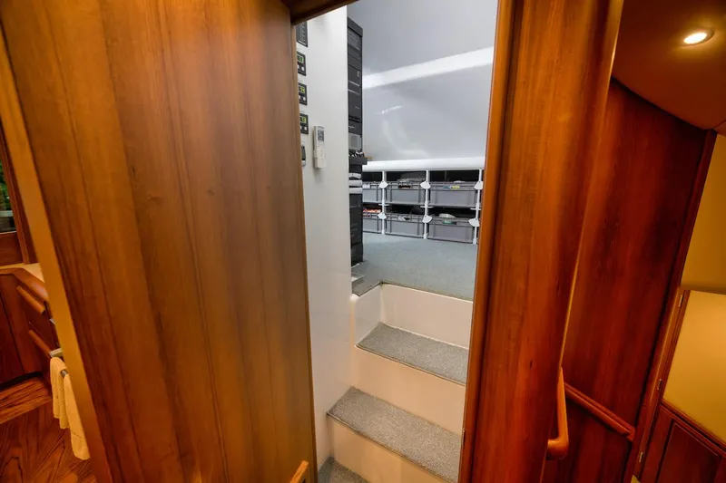 Bree Yacht Photos Pics Interior view of 2016 Merritt 86' Enclosed Flybridge, featuring wooden paneling and carpeted stairs.