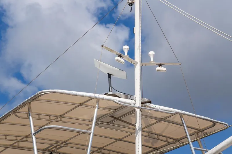 Sandy Isles Yacht Photos Pics 1993 Grand Banks 46 Motoryacht with radar and antennas against a cloudy sky.