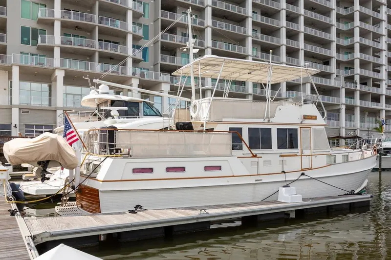 Sandy Isles Yacht Photos Pics 1993 Grand Banks 46 Motoryacht docked at marina, with modern building backdrop.