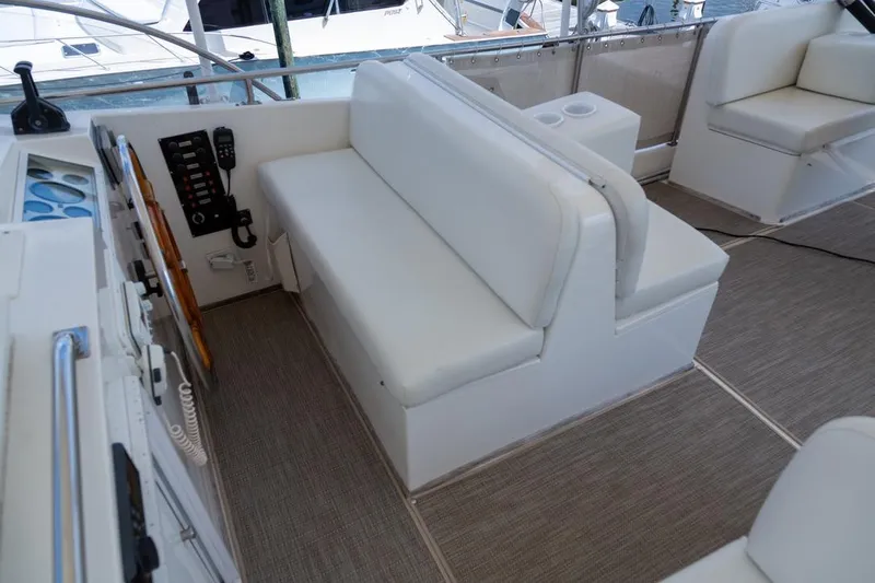 Sandy Isles Yacht Photos Pics 1993 Grand Banks 46 Motoryacht helm seating area with white cushions and control panel.