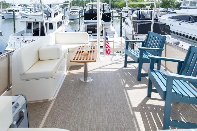 Sandy Isles Yacht Photos Pics Spacious deck of 1993 Grand Banks 46 Motoryacht with seating and table, docked at marina.