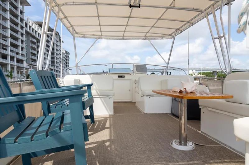 Sandy Isles Yacht Photos Pics Spacious deck of 1993 Grand Banks 46 Motoryacht with seating and table under canopy.