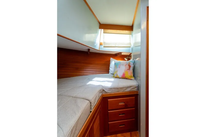 Sandy Isles Yacht Photos Pics Cozy cabin interior of 1993 Grand Banks 46 Motoryacht with wooden accents and colorful pillow.